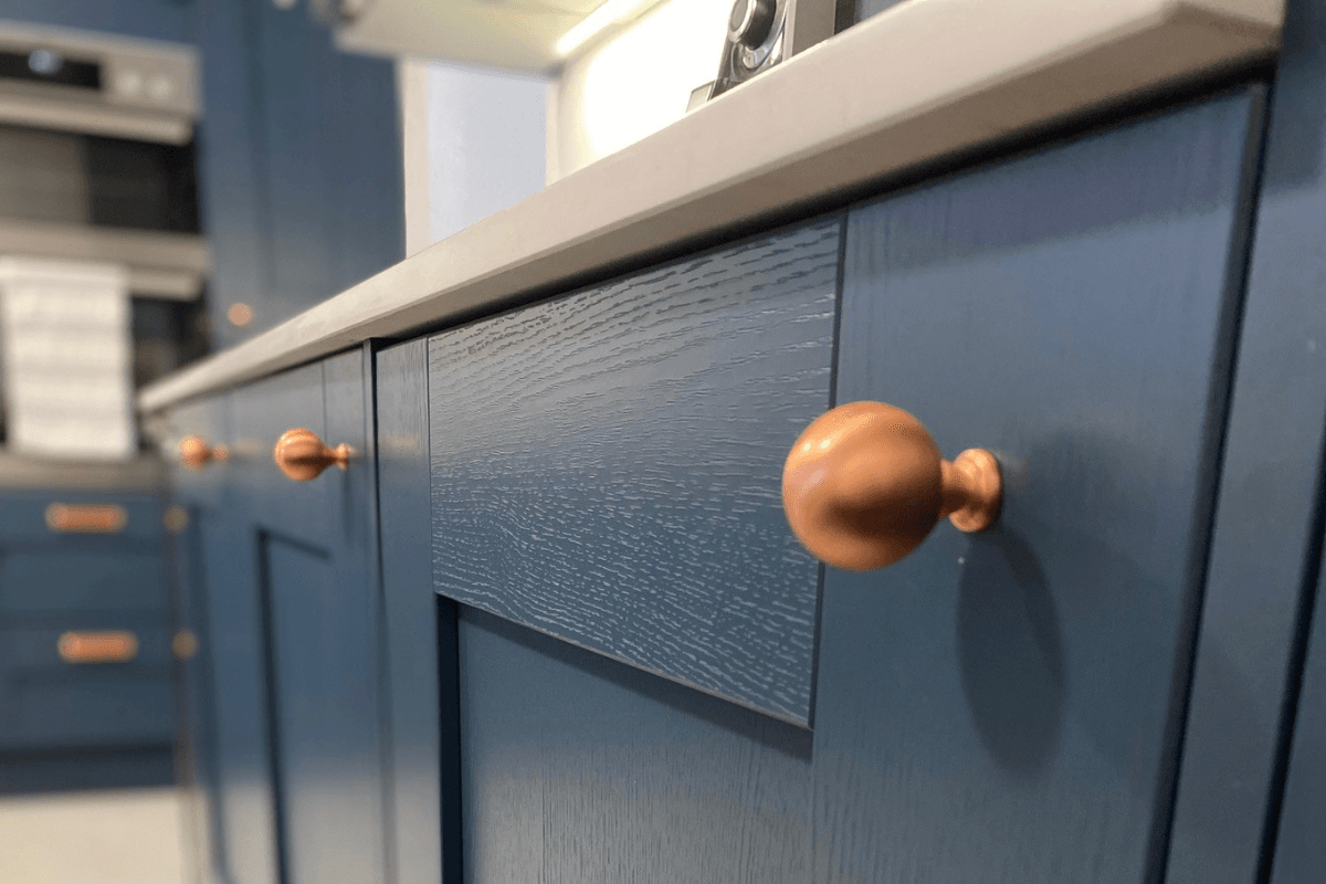 Shaker kitchen with blue doors and copper cup and knob handles